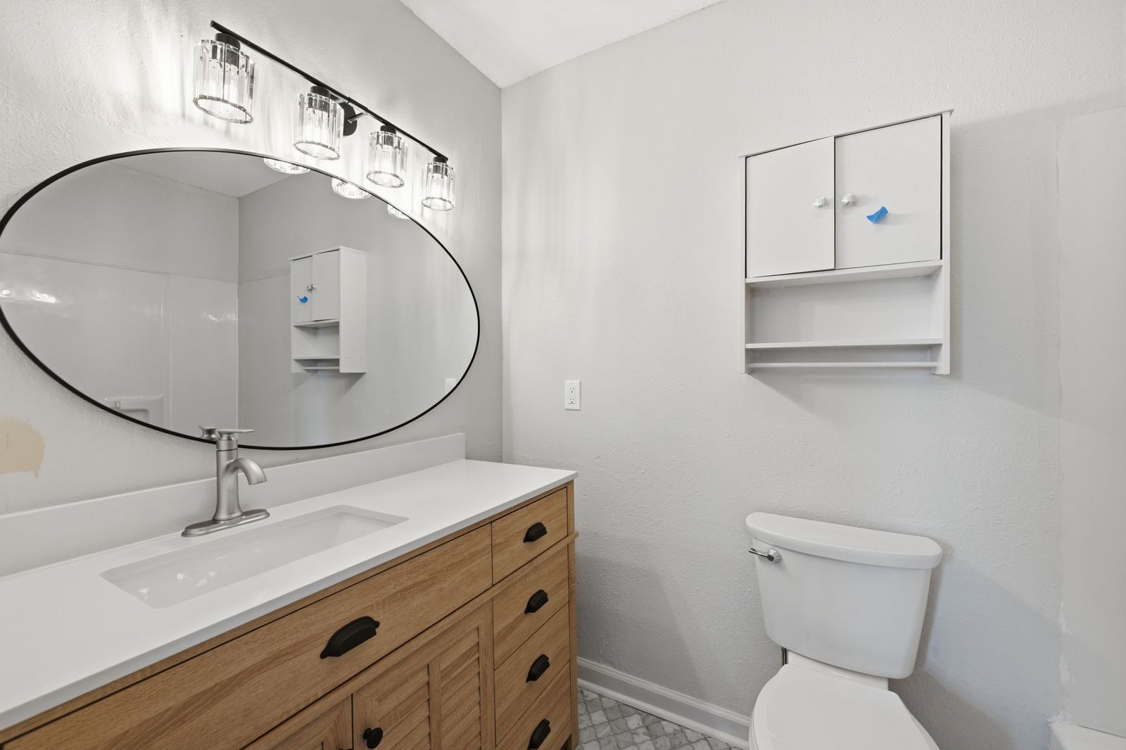 Primary bathroom remodel with custom vanity and oval mirror