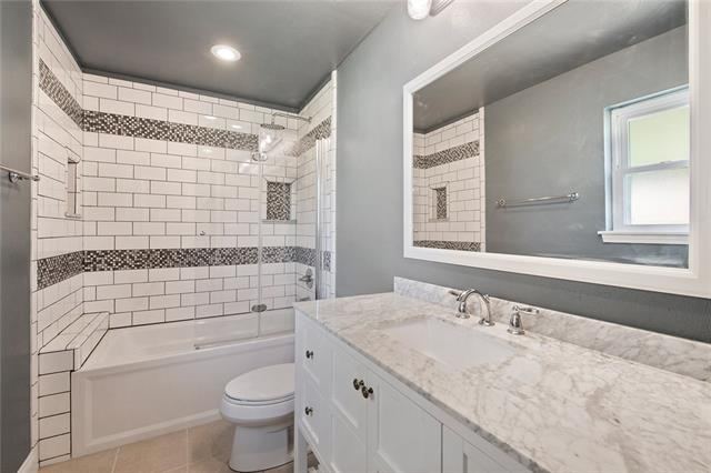 Tub and shower remodel with classic subway tile and marble-look vanity